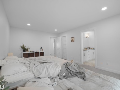 Spacious sleeping area featuring light gray carpeting, recessed ceiling lighting, and a white paneled door - 22650 99A Avenue Nw, Edmonton, AB - Indoor Photo Showing Bedroom