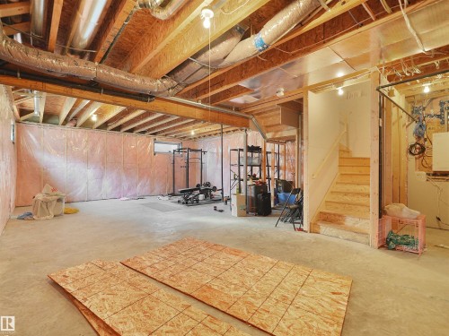 Unfinished basement with exposed wood joists and subflooring, concrete flooring, and an unfinished wood staircase - 22650 99A Avenue Nw, Edmonton, AB - Indoor Photo Showing Basement