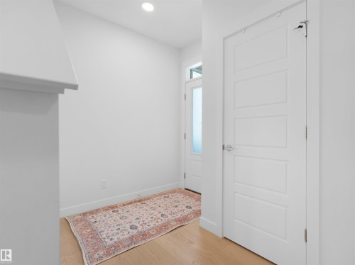 Entryway featuring light wood-finish flooring, recessed lighting, and a contemporary four-panel interior door with chrome hardware - 22650 99A Avenue Nw, Edmonton, AB - Indoor Photo Showing Other Room