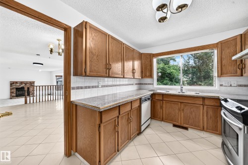 Kitchen featuring wood cabinetry, and a tile backsplash - 17915 99A Avenue Nw, Edmonton, AB 