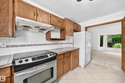 Kitchen featuring tile flooring, wood-finish cabinetry, a stainless steel range - 