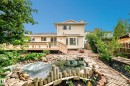 Backyard featuring deck, rock-lined water feature, patio, and mature landscaping - 17915 99A Avenue Nw, Edmonton, AB 