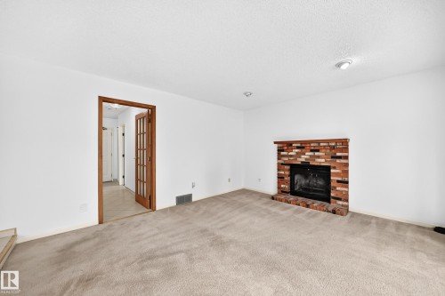 Brick wood burning fireplace with wood mantel - 17915 99A Avenue Nw, Edmonton, AB 