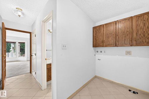 Hallway featuring tile flooring, a semi-flush mount ceiling light, and wood-finish doors - 17915 99A Avenue Nw, Edmonton, AB 