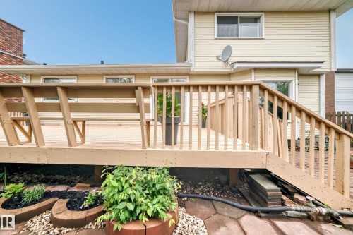 Expansive outdoor deck with built-in bench seating, wood railing, and direct access to interior spaces through sliding glass doors - 17915 99A Avenue Nw, Edmonton, AB 