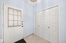 Entryway featuring a paneled door with integrated blind, bi-fold closet doors, and tile flooring - 17915 99A Avenue Nw, Edmonton, AB 