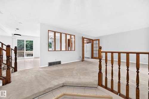 Carpeted living area with wood-finish railings - 17915 99A Avenue Nw, Edmonton, AB 