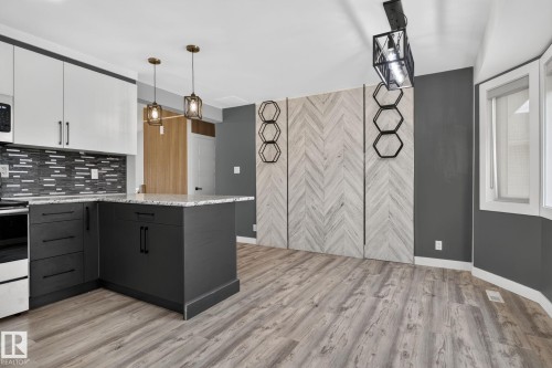 Modern kitchen featuring two-tone cabinetry with white upper and dark lower units - 9530 174 Avenue Nw, Edmonton, AB - Indoor Photo Showing Kitchen