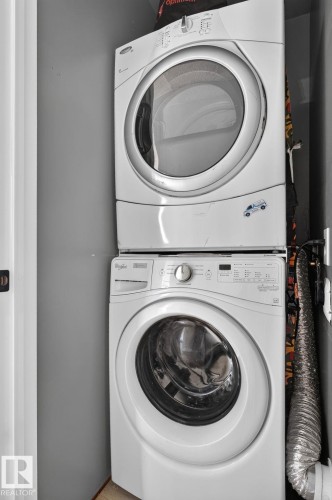 White stackable washer and dryer unit installed within a dedicated laundry area - 9530 174 Avenue Nw, Edmonton, AB - Indoor Photo Showing Laundry Room