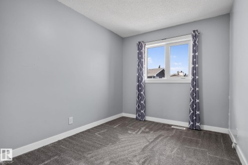 Neutral gray walls with white trim, gray patterned curtains, and a double-pane window - 9530 174 Avenue Nw, Edmonton, AB - Indoor Photo Showing Other Room