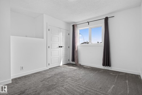Room featuring a double window with black curtain rod, white baseboards, and neutral gray carpeting - 9530 174 Avenue Nw, Edmonton, AB - Indoor Photo Showing Other Room