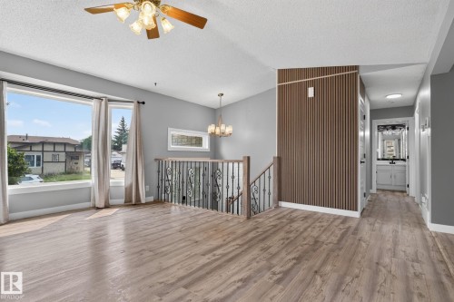 Spacious living area featuring wood-finish flooring and a large picture window - 9530 174 Avenue Nw, Edmonton, AB - Indoor Photo Showing Other Room