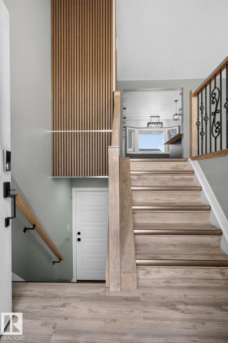 Entryway featuring wood-finish flooring and a contemporary slatted wood accent wall - 9530 174 Avenue Nw, Edmonton, AB - Indoor Photo Showing Other Room