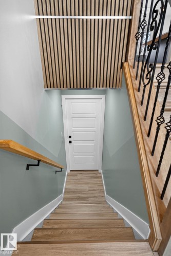 Staircase featuring wood-finish treads and a wood-finish handrail with wrought iron balusters - 9530 174 Avenue Nw, Edmonton, AB - Indoor Photo Showing Other Room