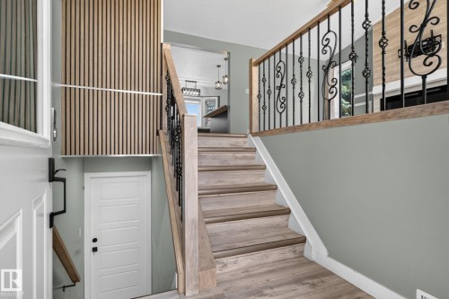 Staircase featuring wood-finish treads and risers, wrought iron balusters, and a solid wood handrail - 9530 174 Avenue Nw, Edmonton, AB - Indoor Photo Showing Other Room