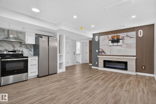 Open-concept living space with wood-finish flooring - 9530 174 Avenue Nw, Edmonton, AB - Indoor With Fireplace