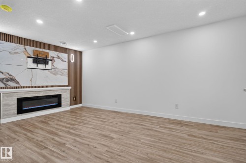 Spacious room featuring wood-finish flooring and recessed lighting - 9530 174 Avenue Nw, Edmonton, AB - Indoor With Fireplace