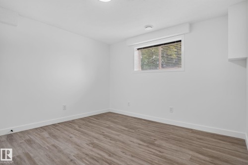 Bright room with wood-finish flooring, white walls, and a window with blinds - 9530 174 Avenue Nw, Edmonton, AB - Indoor Photo Showing Other Room
