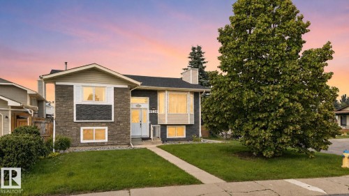 Split-level residence featuring a stone-faced exterior, a prominent gable roofline, and a paved front walkway - 9530 174 Avenue Nw, Edmonton, AB - Outdoor With Facade