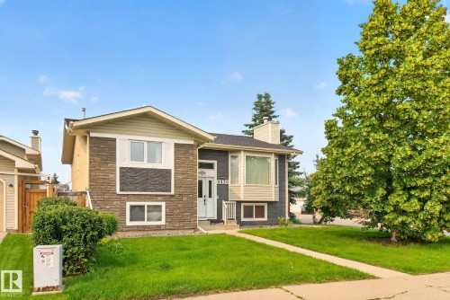 Exterior featuring a blend of stacked stone and siding, a bay window, and a prominent front entry with a white door - 9530 174 Avenue Nw, Edmonton, AB - Outdoor With Facade