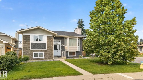 Split-level home featuring a stone facade and siding accents - 9530 174 Avenue Nw, Edmonton, AB - Outdoor With Facade