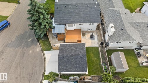 Rear exterior featuring a spacious wooden deck, paved patio, and a detached garage - 9530 174 Avenue Nw, Edmonton, AB - Outdoor