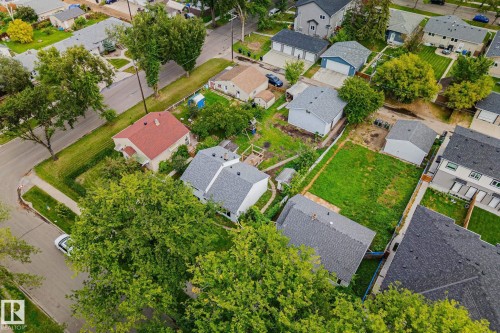 Expansive lot featuring a large grassy area, surrounded by established residences, and bordered by mature trees - 11935 125 Street Nw, Edmonton, AB 