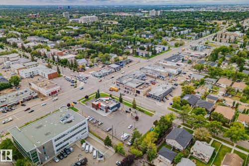 Aerial perspective of a mixed-use neighborhood featuring residential homes, commercial buildings, and roadways - 11935 125 Street Nw, Edmonton, AB 