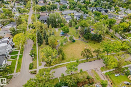 Residential street with sidewalks and mature trees, bordered by green spaces and varying architectural styles - 11935 125 Street Nw, Edmonton, AB 