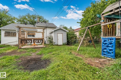 Backyard featuring a wood deck, detached shed, and chain-link fencing - 11935 125 Street Nw, Edmonton, AB 