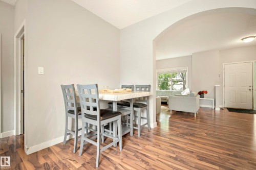 Wood-finish flooring throughout, light gray wall color, and an arched entryway - 1660 Tomlinson Common Nw, Edmonton, AB 