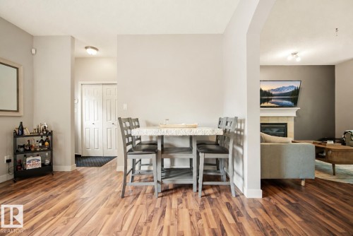 Wood-finish flooring throughout, with a built-in electric fireplace and mantel - 1660 Tomlinson Common Nw, Edmonton, AB 