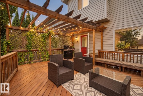 Expansive wood deck with a built-in pergola, integrated privacy lattice, and wood slatted railings - 1660 Tomlinson Common Nw, Edmonton, AB 