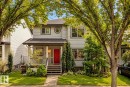 Light gray siding exterior with a red entry door, covered porch, multiple windows, and front landscaping - 1660 Tomlinson Common Nw, Edmonton, AB 