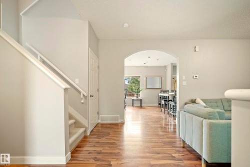 Wood-finish flooring, staircase with carpeted treads, archway, and recessed lighting - 1660 Tomlinson Common Nw, Edmonton, AB 