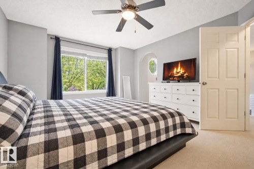 Recessed lighting and ceiling fan, arch niche detail, large window, paneled door, and neutral-toned carpet - 1660 Tomlinson Common Nw, Edmonton, AB 