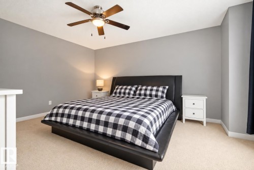 Neutral wall color, carpet flooring, ceiling fan with integrated lighting, and white trim - 1660 Tomlinson Common Nw, Edmonton, AB 