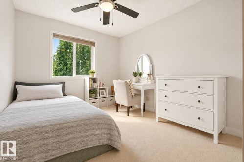 Light-colored walls, window with roller shade, ceiling fan with light fixture, light-colored carpeting, integrated shelving unit - 1660 Tomlinson Common Nw, Edmonton, AB 