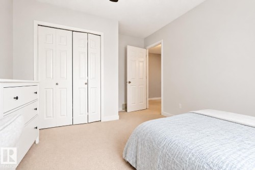 Neutral wall colors with carpet flooring, a bifold closet, and a paneled door - 1660 Tomlinson Common Nw, Edmonton, AB 