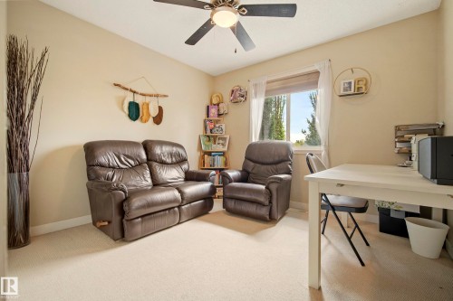Carpeted flooring, ceiling fan with integrated lighting, built-in shelving, and a prominent window - 1660 Tomlinson Common Nw, Edmonton, AB 