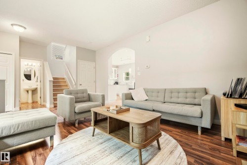 Wood-finish flooring throughout, archway entry, and staircase with white risers - 1660 Tomlinson Common Nw, Edmonton, AB 