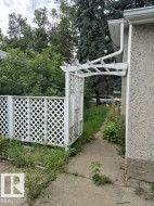Lattice fencing with an arched arbor entry and concrete pathway - 