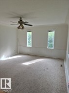 Recessed ceiling, ceiling fan with integrated lighting, two vertically oriented windows, white wall paneling, and wall-to-wall carpeting - 