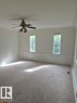 Recessed ceiling, ceiling fan with integrated lighting, two vertically oriented windows, white wall paneling, and wall-to-wall carpeting - 12005 45 Street Nw, Edmonton, AB 