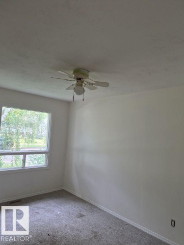 Neutral wall finishes, window with exterior scenery, and a ceiling fan with integrated lighting - 12005 45 Street Nw, Edmonton, AB 