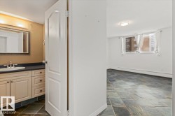 Bathroom vanity with light-colored cabinetry, undermount sink, and a framed mirror - 