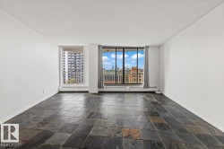 Expansive room featuring large format slate tile flooring, white painted walls, and abundant natural light through multiple windows - 