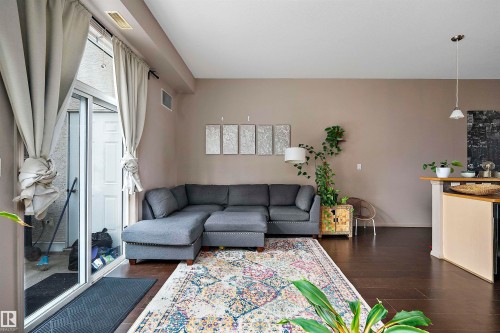 Expansive open-concept living area featuring dark wood-finish flooring - #713 10503 98 Av Nw, Edmonton, AB - Indoor Photo Showing Living Room