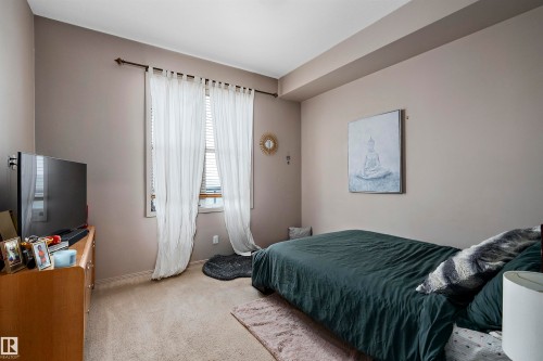 Carpeted room with a single window featuring blinds and sheer curtains, complemented by a ceiling soffit - #713 10503 98 Av Nw, Edmonton, AB - Indoor Photo Showing Bedroom