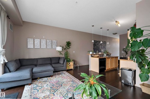 Open-concept living area with dark wood-finish flooring - #713 10503 98 Av Nw, Edmonton, AB - Indoor Photo Showing Living Room